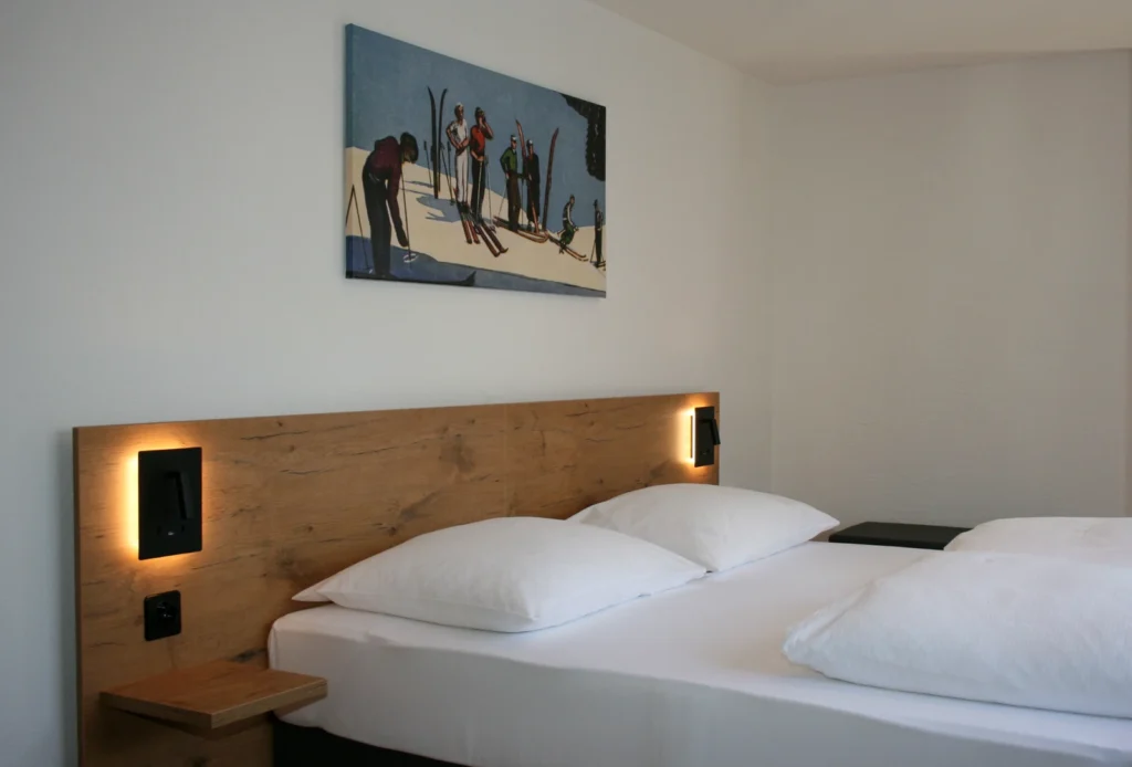 Boxspringbetten mit Leselampen und Skifahrerbild