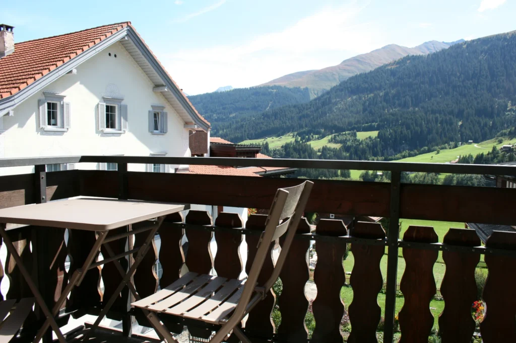 Balkon mit Tisch und Blick auf die Berge bei Sedrun