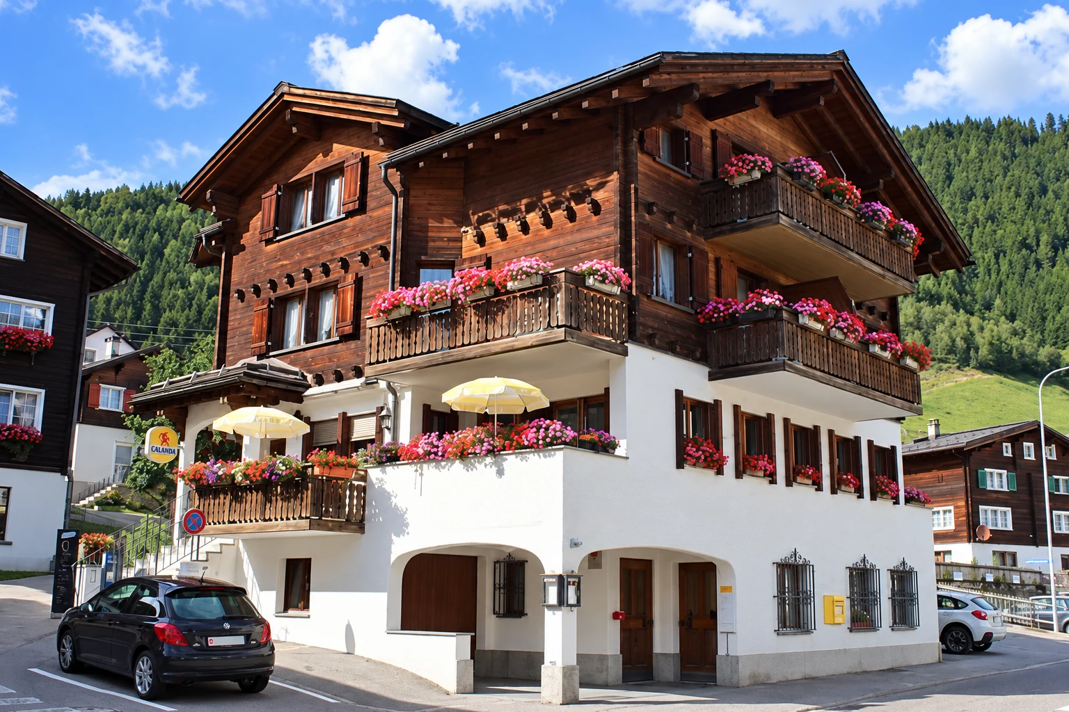 Aussenansicht der CRUNA LODGE mit Holzfassade und Blumenbalkonen